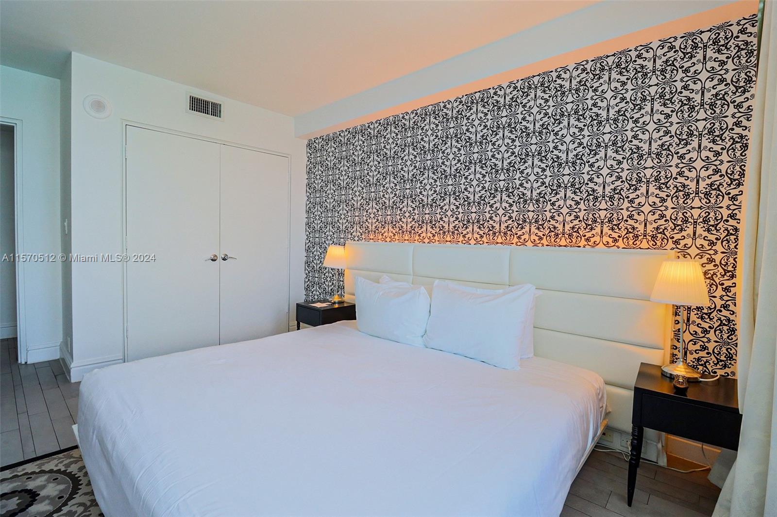 1100 West Avenue, Unit 816 Miami Beach, FL 33139 - Photo 15 of 22 a bedroom with a bed and a chair