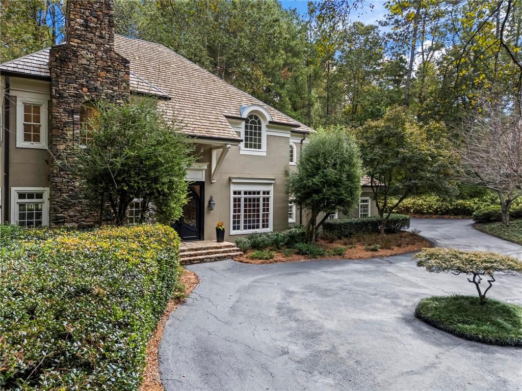 1235 West Garmon Road Northwest Atlanta, GA 30327 - Photo 2 of 46 a front view of a house with a yard and shrubs