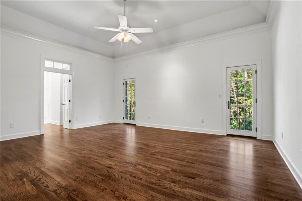 1235 West Garmon Road Northwest Atlanta, GA 30327 - Photo 21 of 46 an empty room with wooden floor chandelier fan and windows