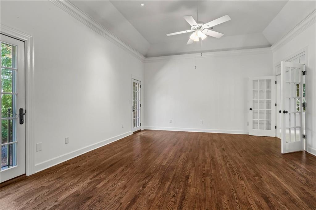 1235 West Garmon Road Northwest Atlanta, GA 30327 - Photo 22 of 46 an empty room with wooden floor and a ceiling fan