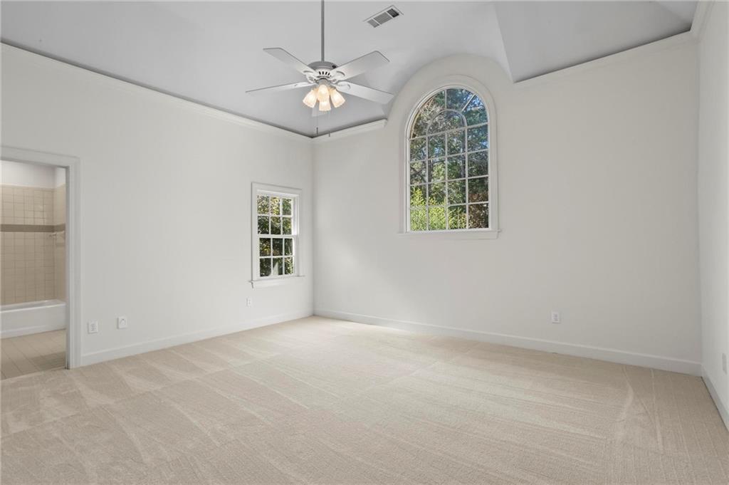 1235 West Garmon Road Northwest Atlanta, GA 30327 - Photo 30 of 46 an empty room with windows and chandelier fan