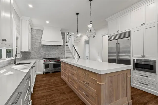 a large kitchen with stainless steel appliances granite countertop a stove a sink and a refrigerator