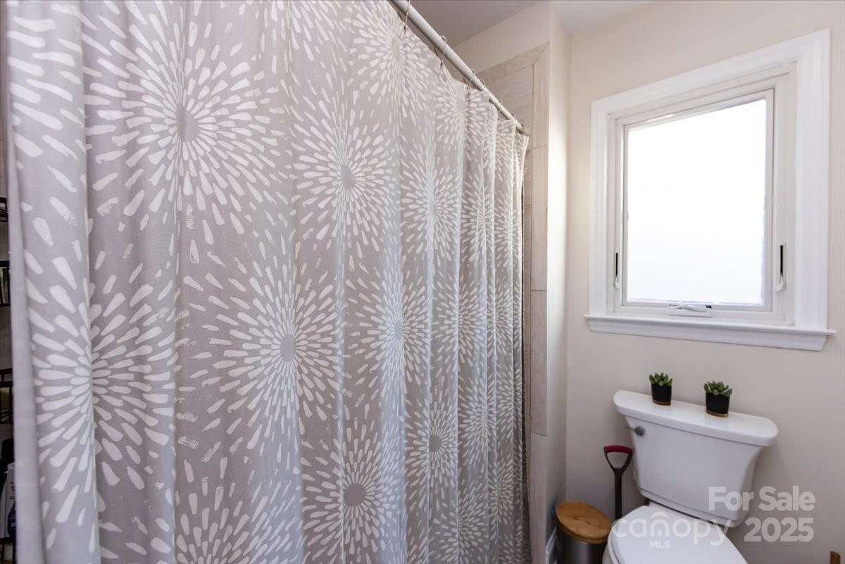 10937 Back Ridge Road Charlotte, NC 28277 - Photo 33 of 45 a white toilet sitting next to a shower curtain