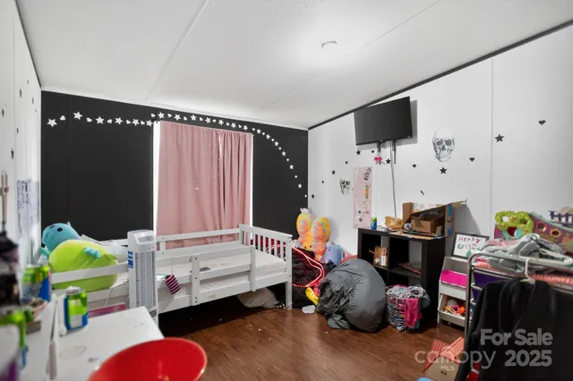 a view of a bedroom with fridge and workspace