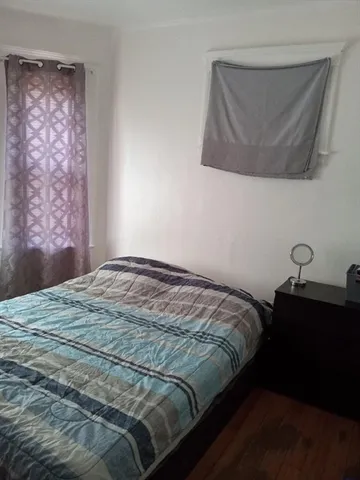 a bed sitting in a bedroom next to a window