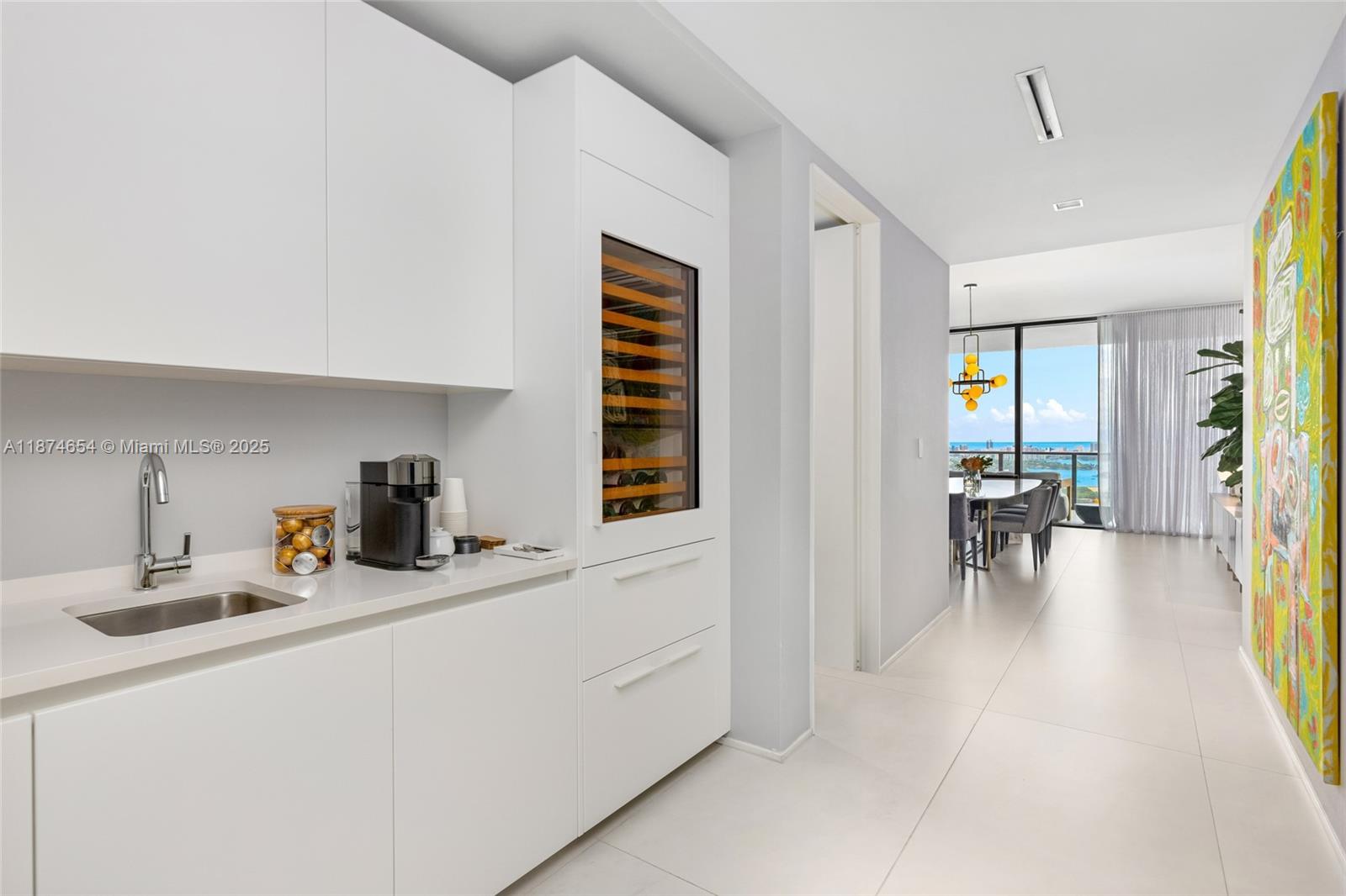 1000 Biscayne Boulevard, Unit 3801 Miami, FL 33132 - Photo 13 of 31 a kitchen with sink cabinets and dining table