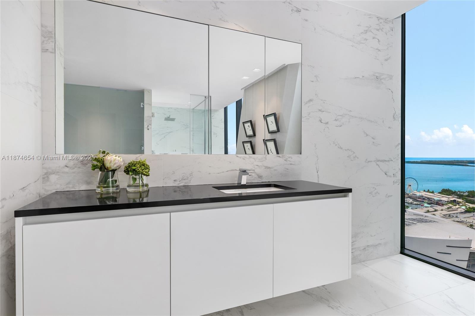 1000 Biscayne Boulevard, Unit 3801 Miami, FL 33132 - Photo 16 of 31 a bathroom with a granite countertop sink and a mirror
