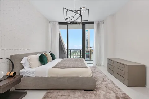 a spacious bedroom with a bed and glass window
