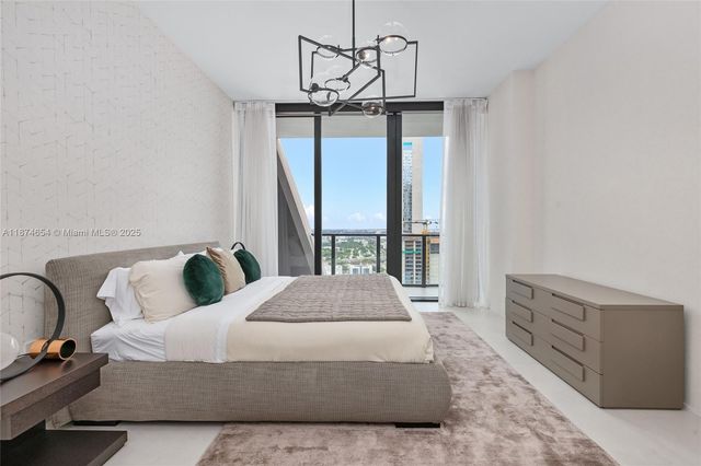 a spacious bedroom with a bed and glass window
