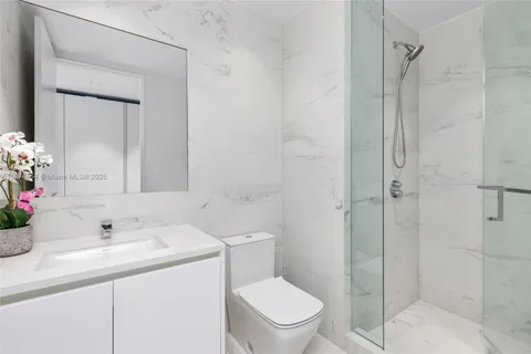 a bedroom with a bed and large windows