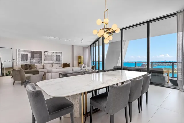 a view of a dining room and livingroom with furniture wooden floor a chandelier