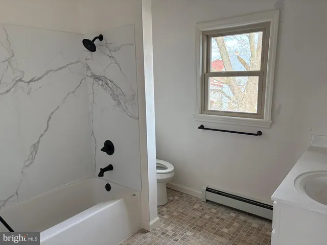 a bath room with a toilet a bath tub and a shower