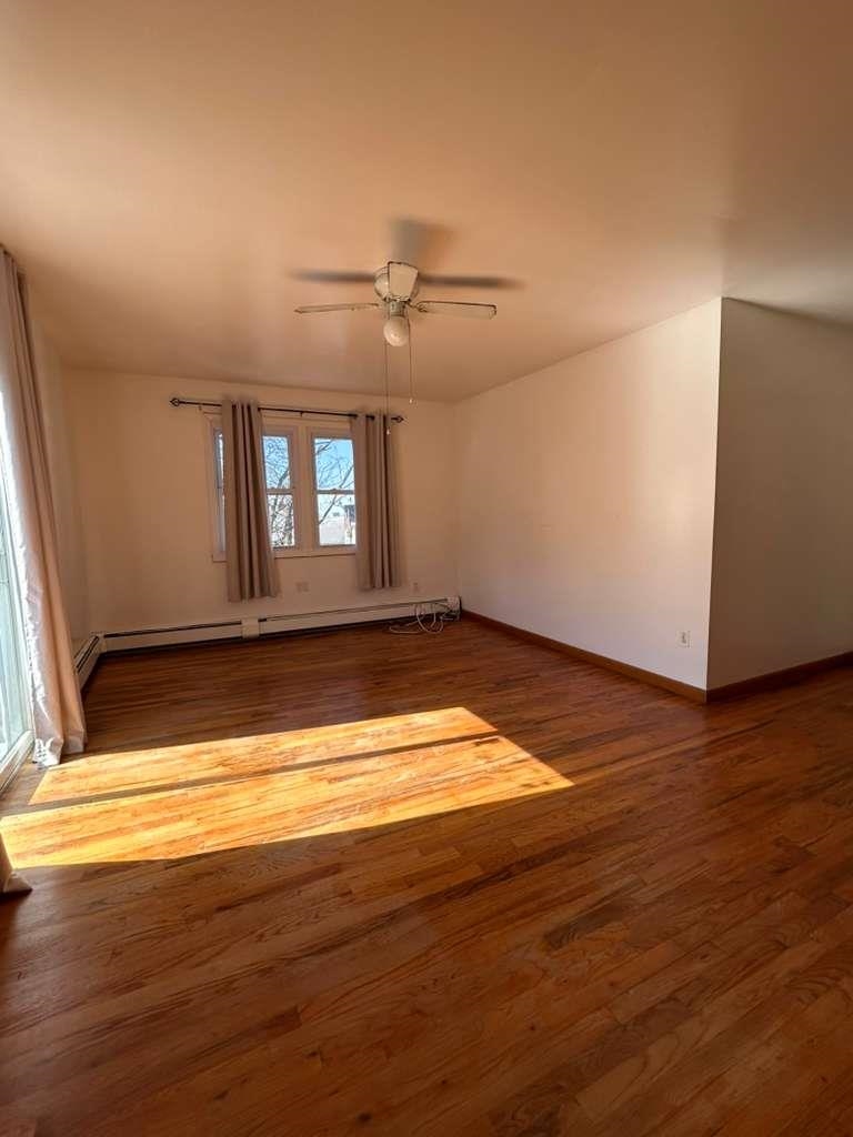 805 Secaucus Road, Unit 2 Jersey City, NJ 07307 - Photo 4 of 21 a view of empty room with wooden floor and fan