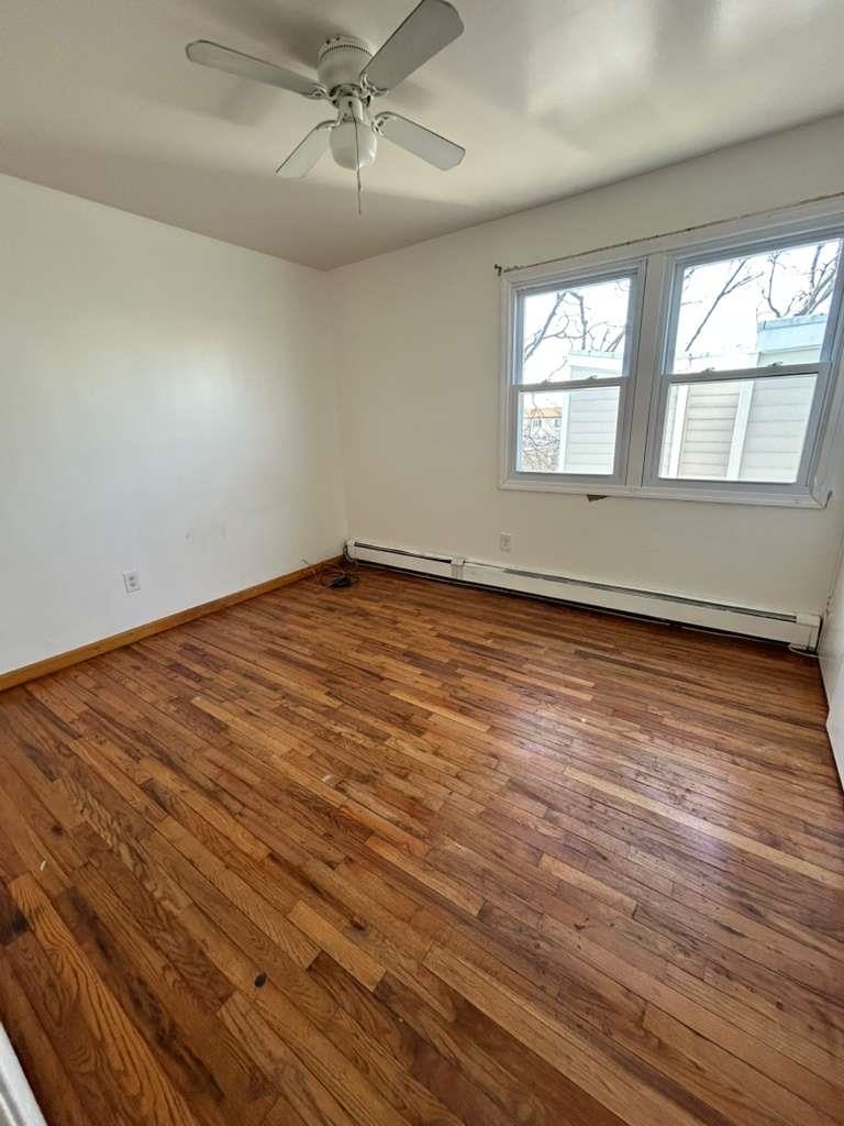 805 Secaucus Road, Unit 2 Jersey City, NJ 07307 - Photo 5 of 21 an empty room with wooden floor fan and windows