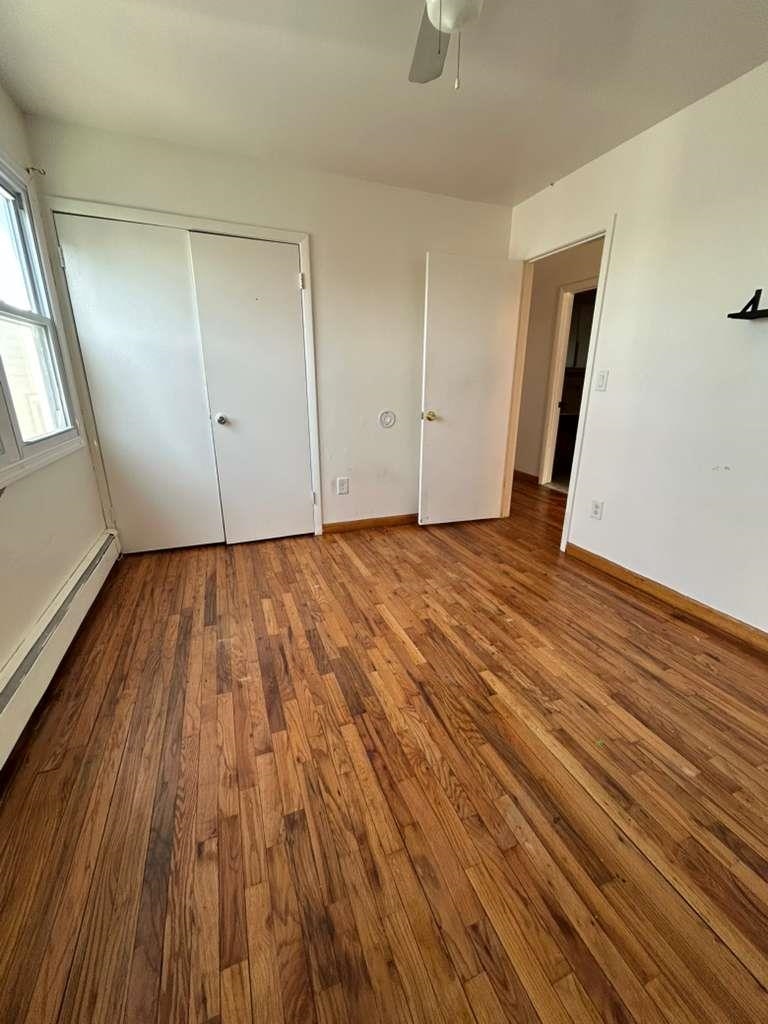 805 Secaucus Road, Unit 2 Jersey City, NJ 07307 - Photo 7 of 21 a view of an empty room with wooden floor and a window