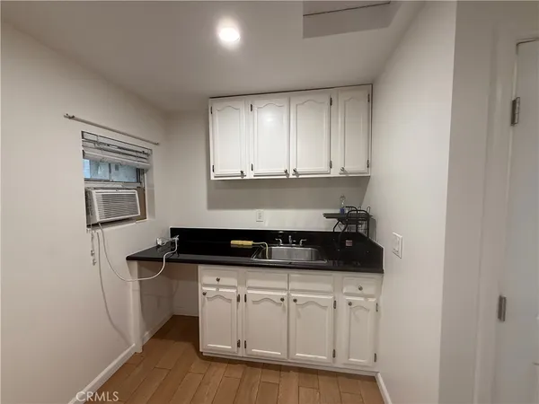a kitchen with granite countertop a sink a stove a microwave and cabinets