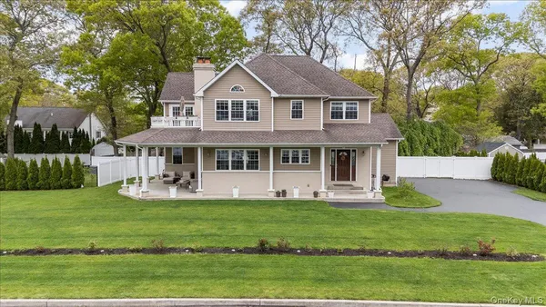 a front view of a house with garden and trees
