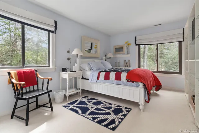 a bathroom with a toilet a sink a mirror and a window