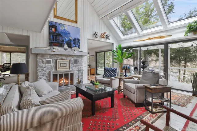 a living room with furniture fireplace and a large window