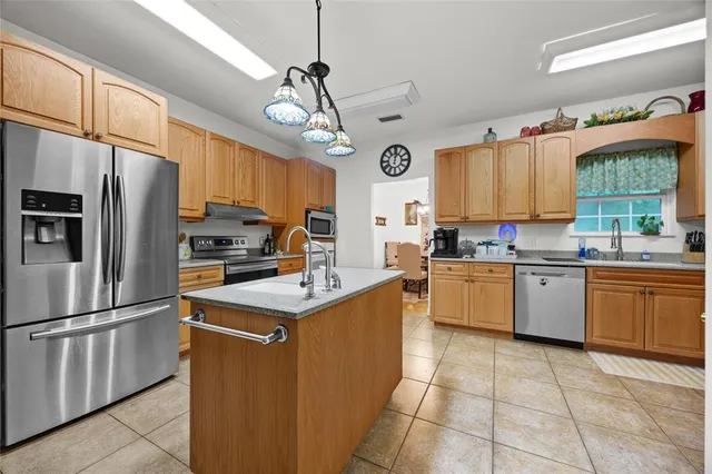 a kitchen with a sink counter top space cabinets and stainless steel appliances