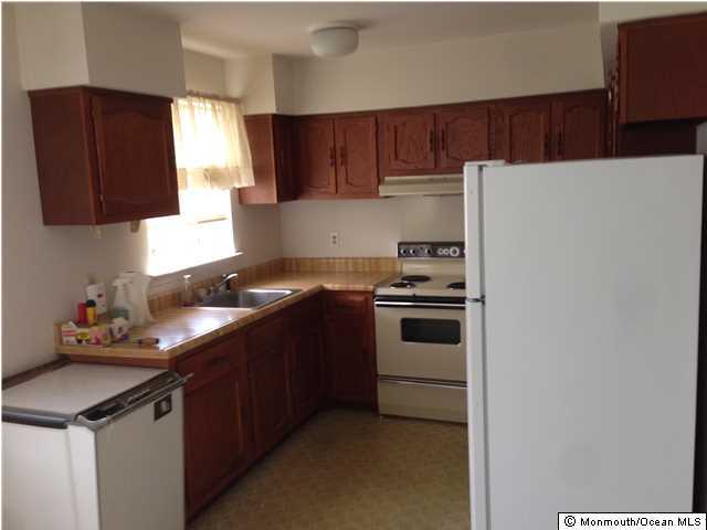 18 Spring Street, Unit B Manchester Township, NJ 08759 - Photo 3 of 4 a kitchen with granite countertop wood cabinets and white appliances