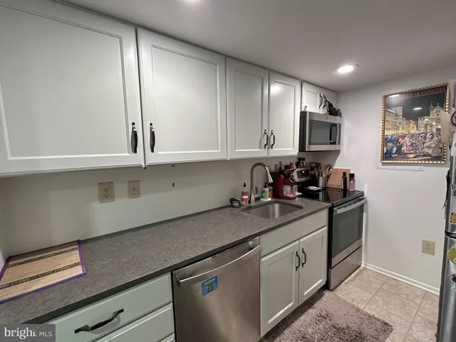 a kitchen with stainless steel appliances granite countertop a sink a stove and a microwave