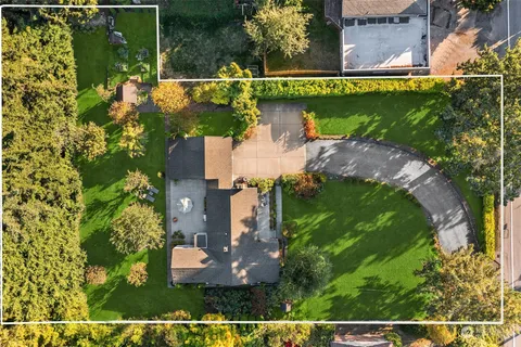 an aerial view of a house with a garden and lake view