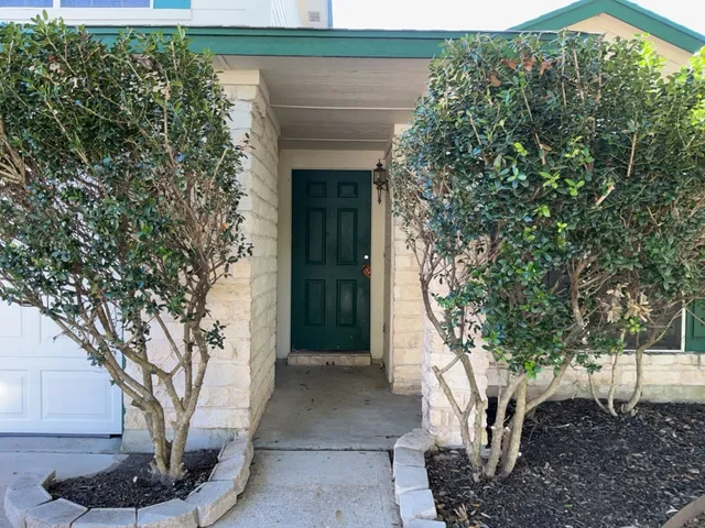 a front view of a house with plants