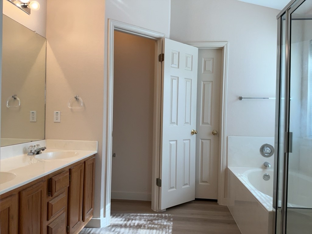1511 Thibodeaux Drive Round Rock, TX 78664 - Photo 22 of 31 Full bathroom featuring a bath, double vanity, a stall shower, and light wood-style floors