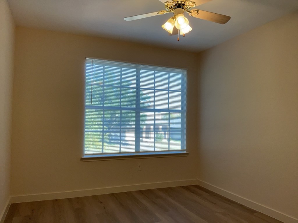 1511 Thibodeaux Drive Round Rock, TX 78664 - Photo 25 of 31 Empty room with wood finished floors and a ceiling fan