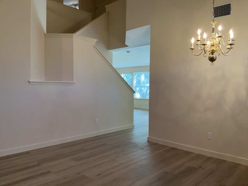 1511 Thibodeaux Drive Round Rock, TX 78664 - Photo 7 of 31 Unfurnished dining area with a chandelier, dark wood finished floors, and a high ceiling