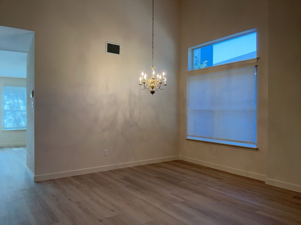 1511 Thibodeaux Drive Round Rock, TX 78664 - Photo 9 of 31 Unfurnished dining area featuring a towering ceiling, dark wood finished floors, and a chandelier