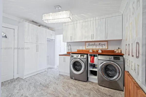 a utility room with sink dryer and washer