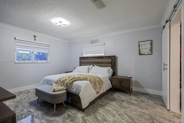 a bedroom with a bed table and chair