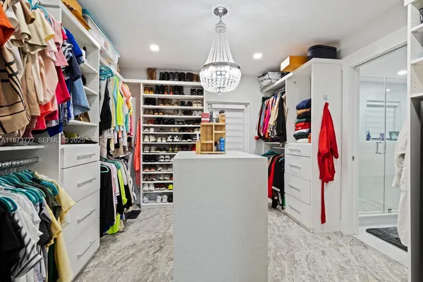 a view of walk in closet with clothes