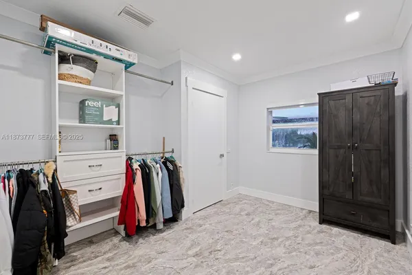 a view of walk in closet with clothes and shoes