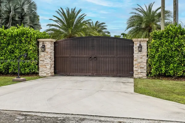 a white house with a flower garden and wooden fence