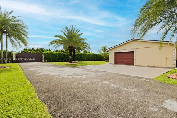 a front view of a house with a yard and trees