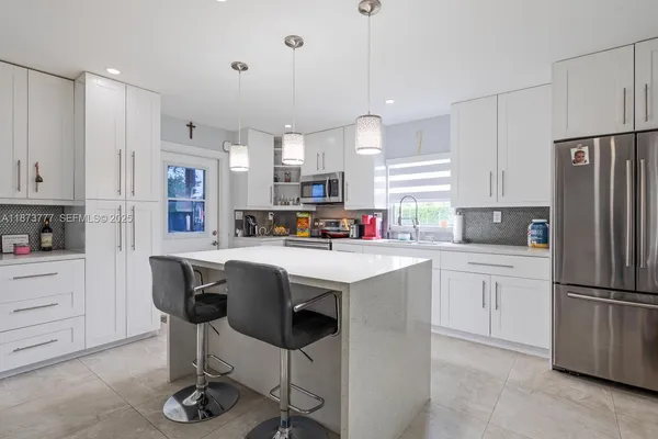 a kitchen with refrigerator and window