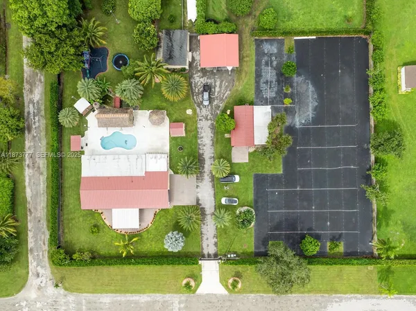 an aerial view of a tennis ground and a large pool
