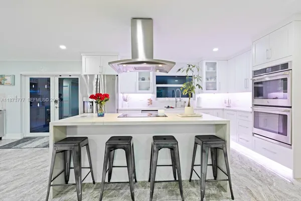 a kitchen with stainless steel appliances a dining table and chairs