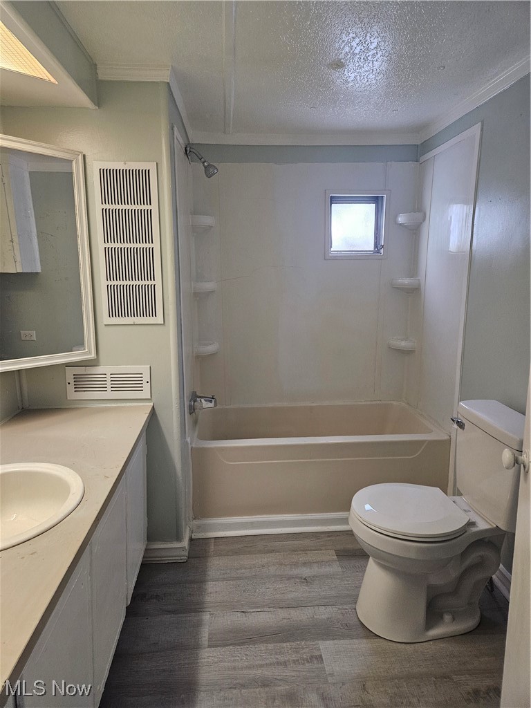2305 East Waterloo Road Akron, OH 44312 - Photo 5 of 12 Bathroom featuring vanity, dark wood-style floors, shower / washtub combination, a textured ceiling, and ornamental molding