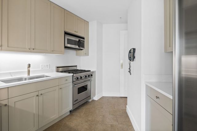 a kitchen with white cabinets and stainless steel appliances