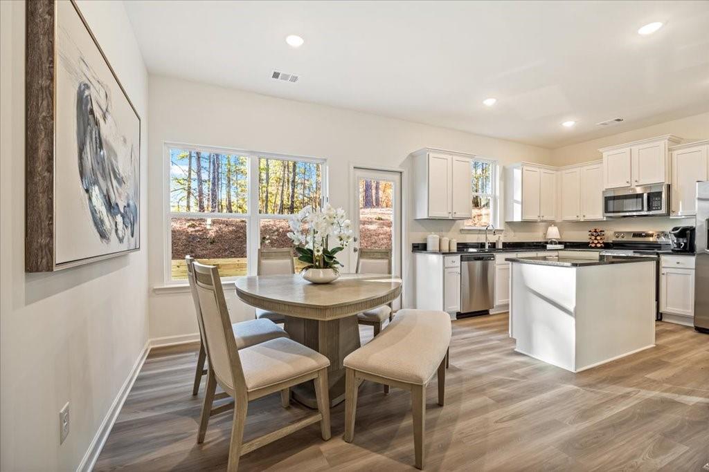 1833 Dawn Road, Unit 22 Conyers, GA 30013 - Photo 7 of 37 a kitchen with stainless steel appliances granite countertop a stove a refrigerator a kitchen island with a dining table and chairs