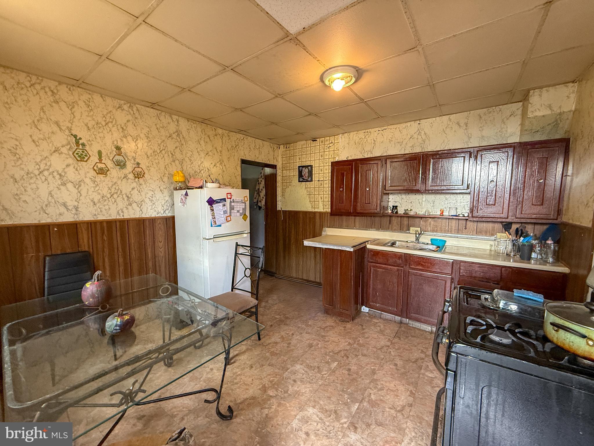 114 North 10th Street Reading, PA 19601 - Photo 6 of 43 a kitchen with a refrigerator and a stove top oven