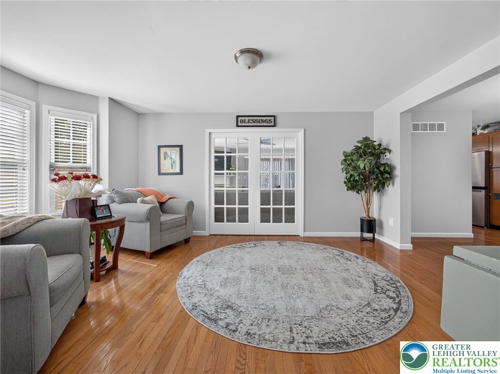 4148 Ross Road Bethlehem, PA 18020 - Photo 44 of 67 Hardwood floors and ample natural light define this welcoming living area, featuring double French doors leading to the kitchen.