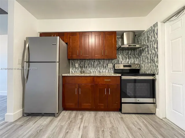 a kitchen with granite countertop a refrigerator and a stove