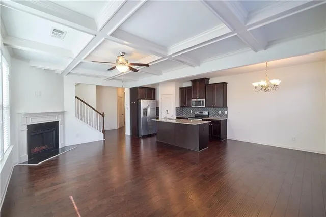 a view of an empty room with wooden floor and a fireplace