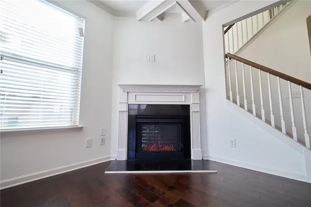 an open kitchen with wooden floor and a large window