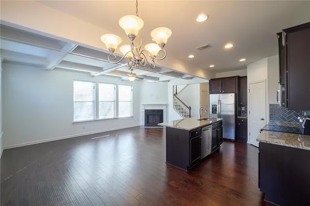 a kitchen with stainless steel appliances granite countertop a refrigerator a sink and a stove